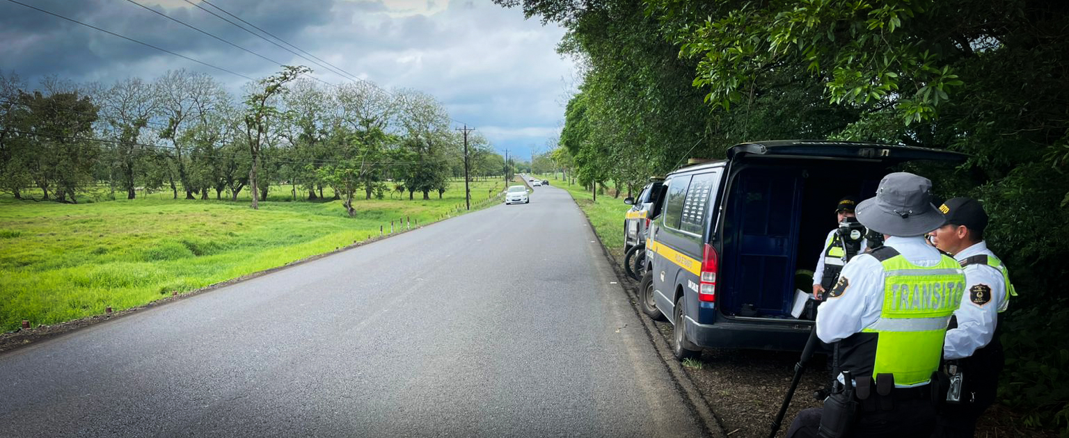 Fotografía que muestra a tres oficiales en operativo de velocidad en una carretera rural