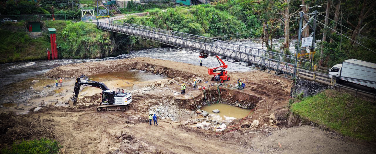 Maquinaria pesada trabando en el cause del río Grande de Orosi en el sector de Palomo para construir un nuevo puente
