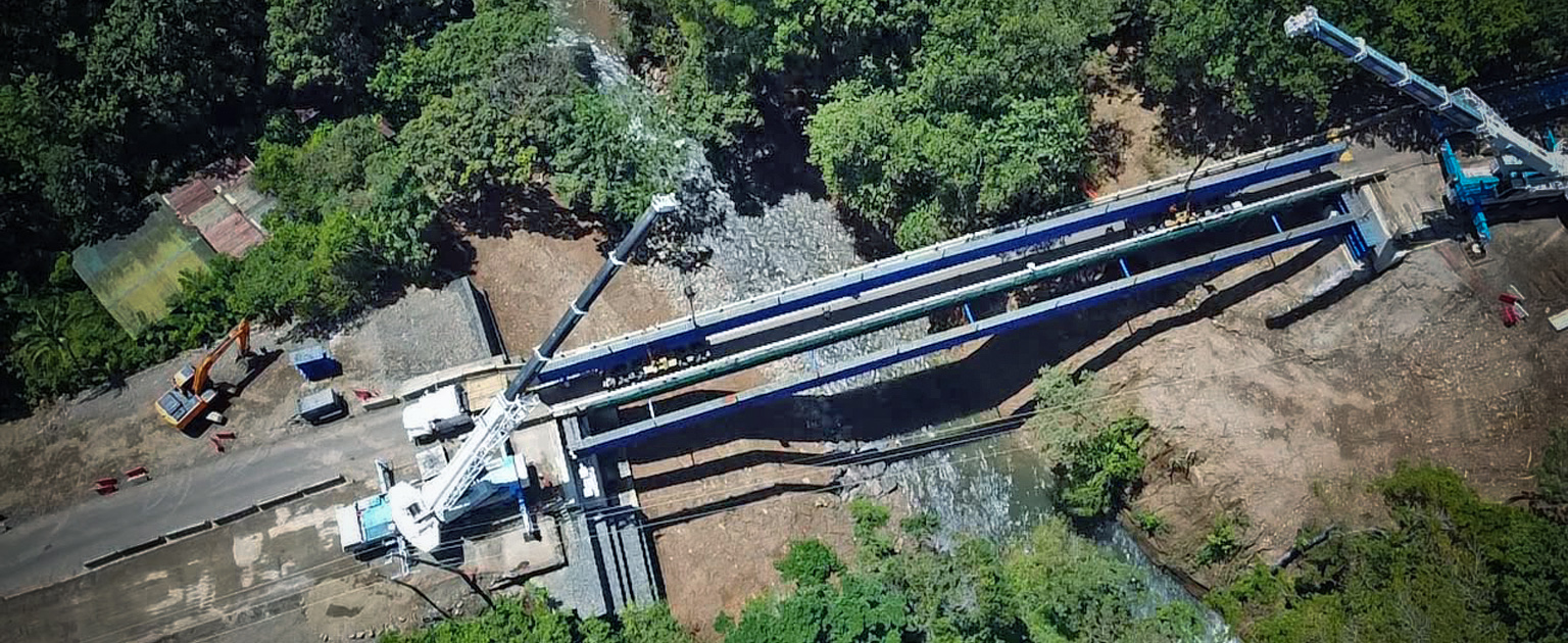Fotografía aérea que muestra la colocación de vigas en el puente sobre el río Tenorio