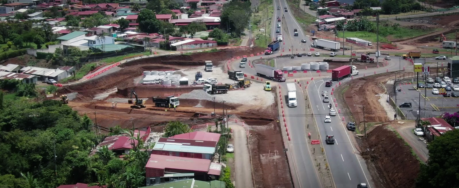 Toma aérea de la construcción del intercambio a dos niveles a la entrada del cantón de San Ramón sobre la RN 1, me muestran vehículos circulando, maquinaria, movimiento de tierras y dispositivos para la canalización del tránsito
