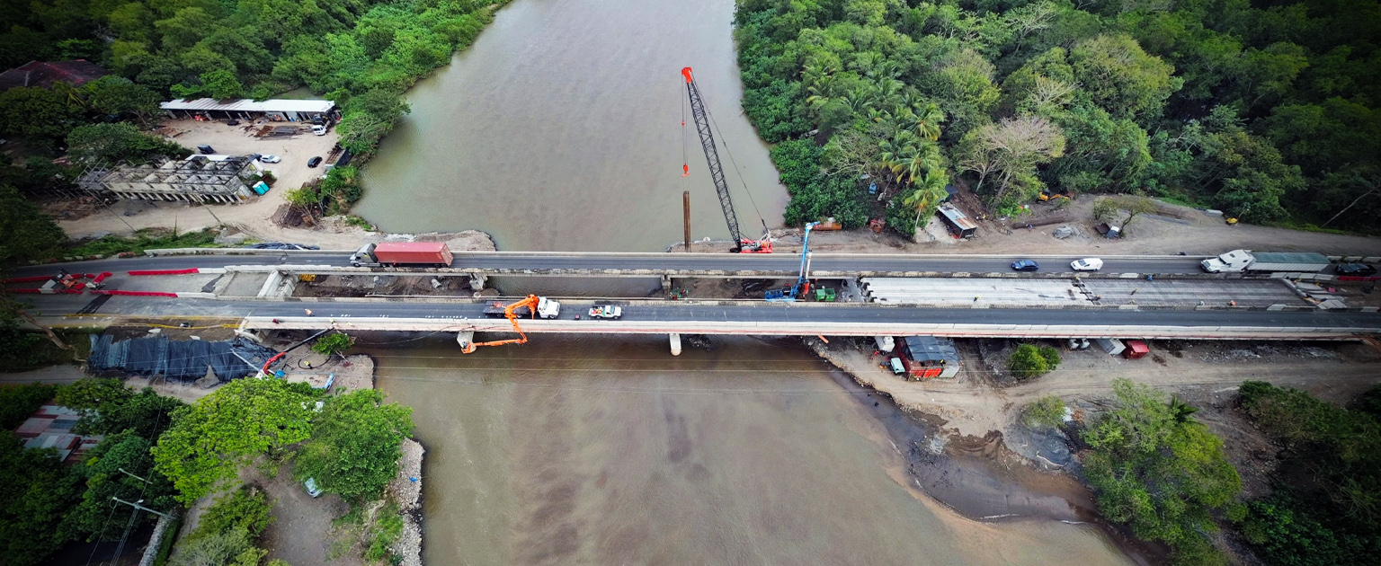 Fotografía aérea que muestra el puente sobre el río Barranca y maquinaria trabajando en sitio