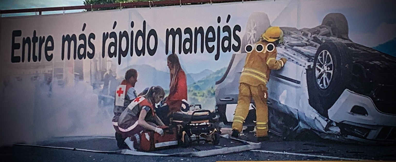 Valla publicitaria: "Entre más rápido manejas.." con foto de un accidente de tránsito
