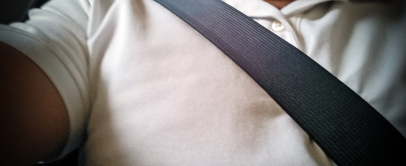 Foto en un plano cerrado del cinturón sobre un hombre de camisa blanca.