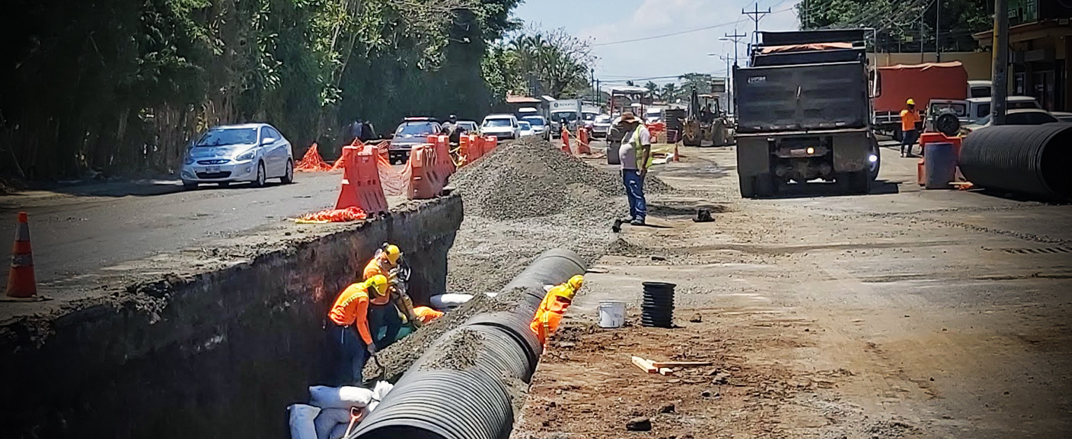hombres trabajando instalando tubería, al lado de la calle