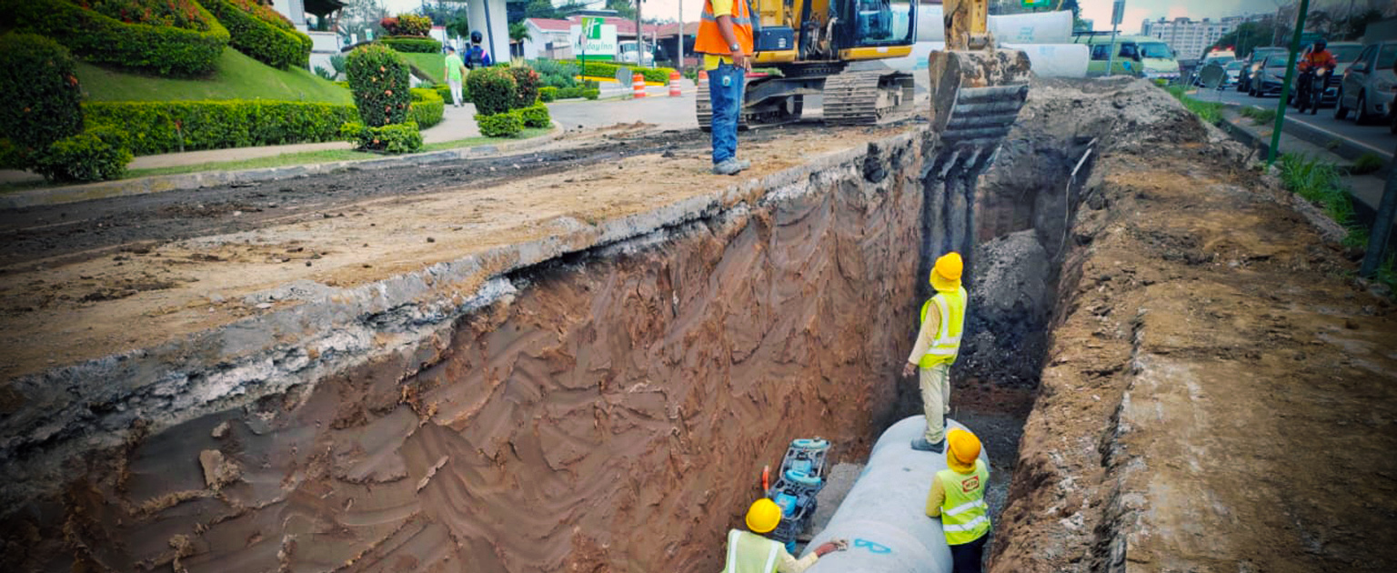 Hombres trabajando dentro de excavación donde se colocará la tubería