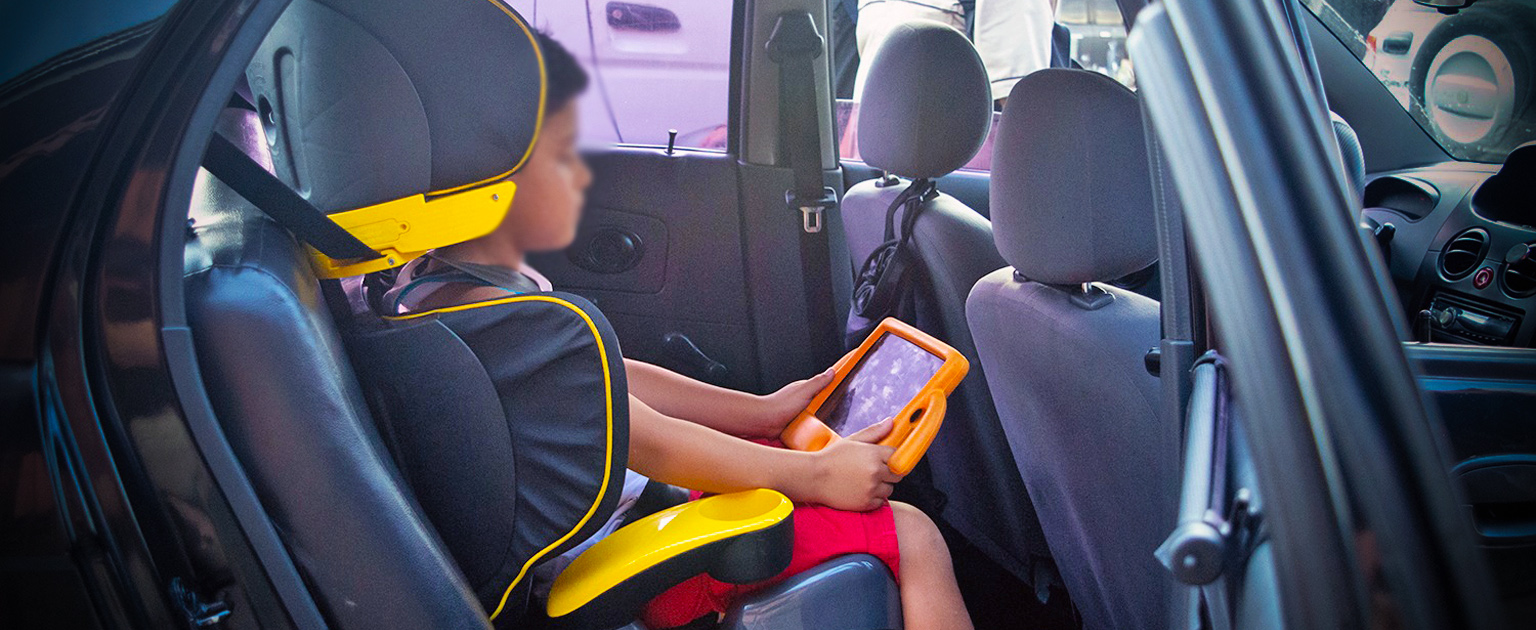 Niño sentado en dispositivo de seguridad dentro del vehículo