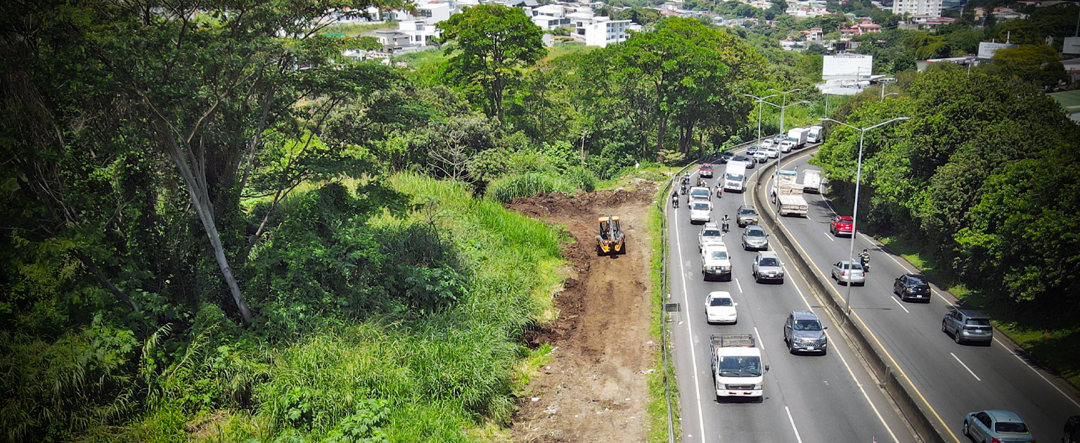 Foto aérea. Maquinaria trabajando al costado de la carretera de Hatillo, donde pasan vehículos.