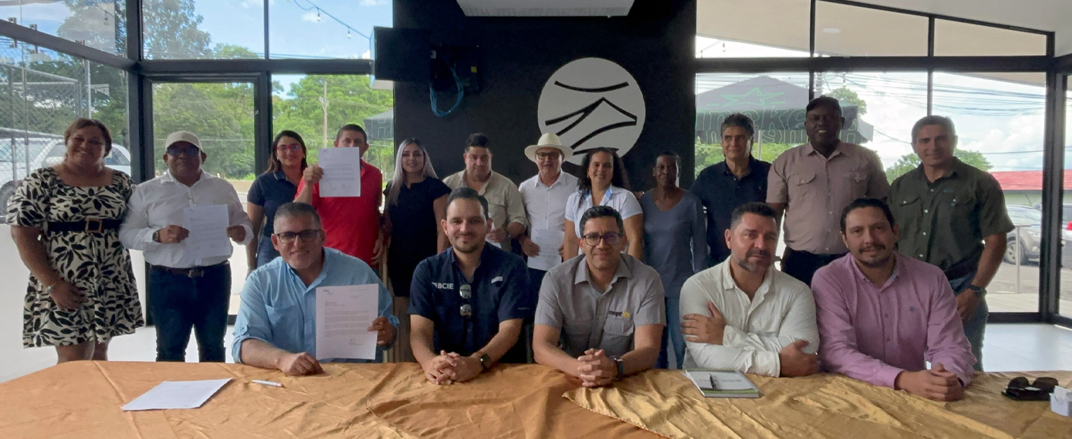 En una mesa, en el centro está sentado el Ministro Mauricio Batalla, Viceministro, Efraím Zeledón y Director del BCIE. Les rodean todos los alcaldes de la provincia de Limón.