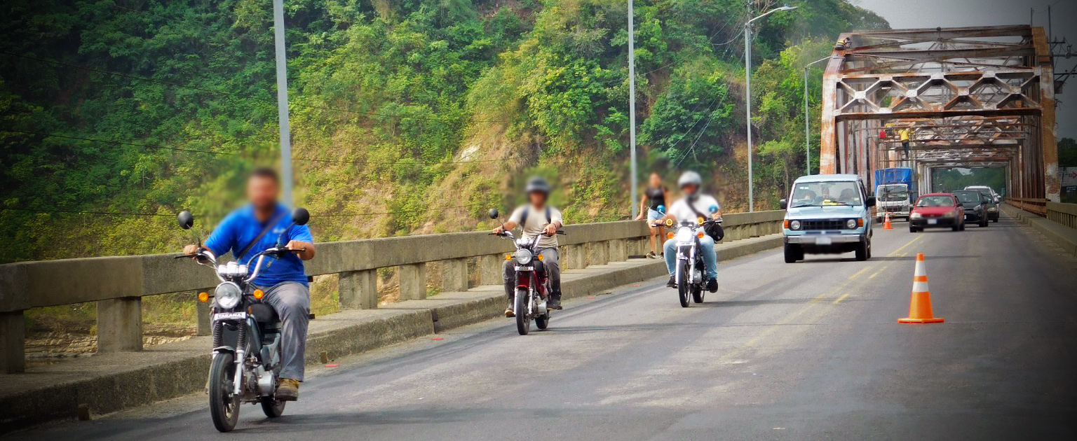 Fotografía que muestra a varios motociclistas circulando en carretera un sin casco