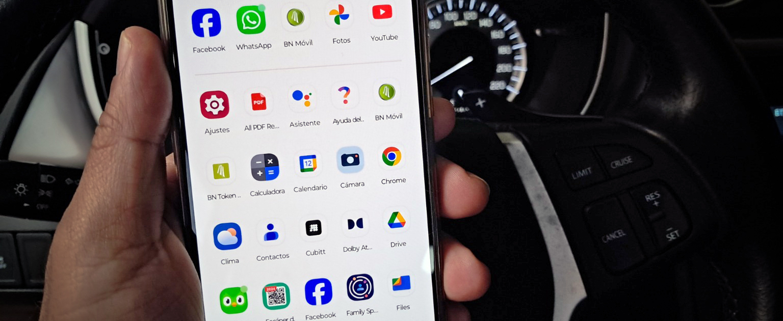 Celular en mano  y de fondo tablero de vehículo