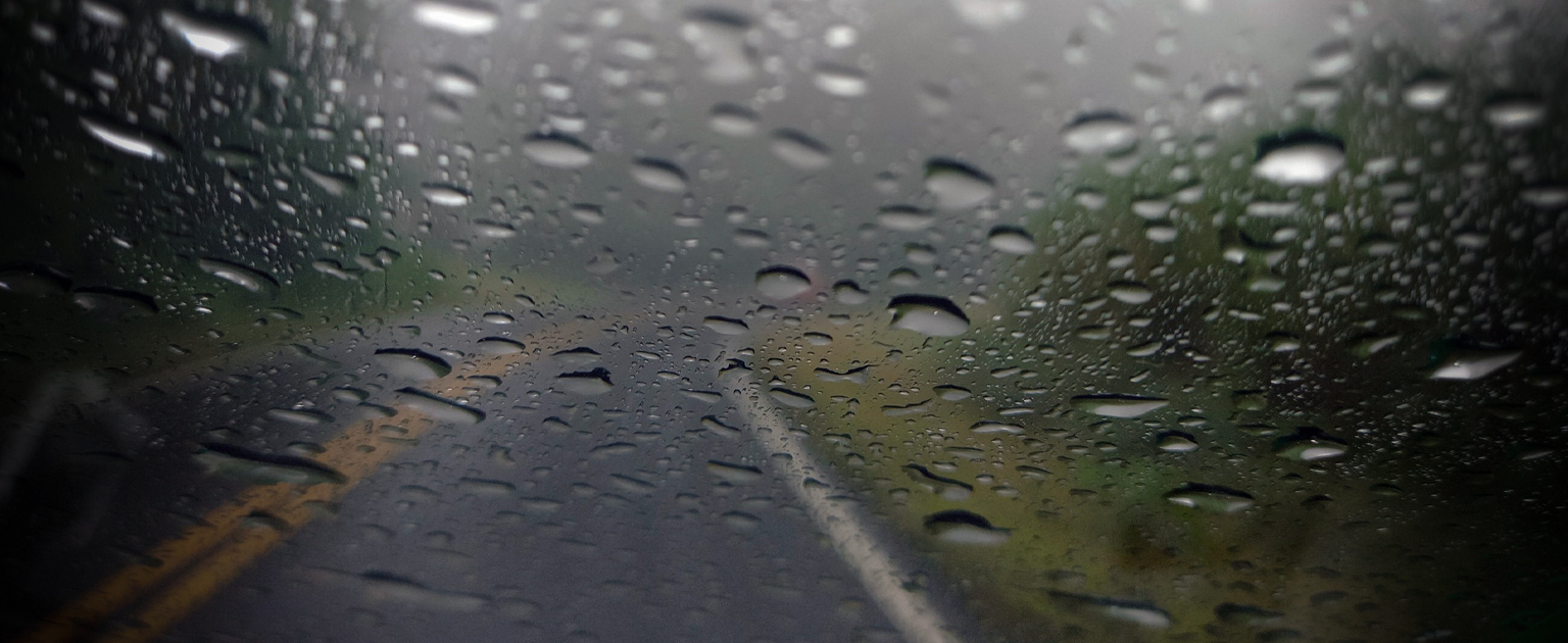Fotografía ilustrativa que muestra una carretera con lluvia a través del parabrisas de un vehículo