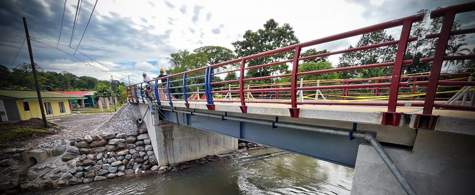 Costado de puente, con dos trabajadores encima.