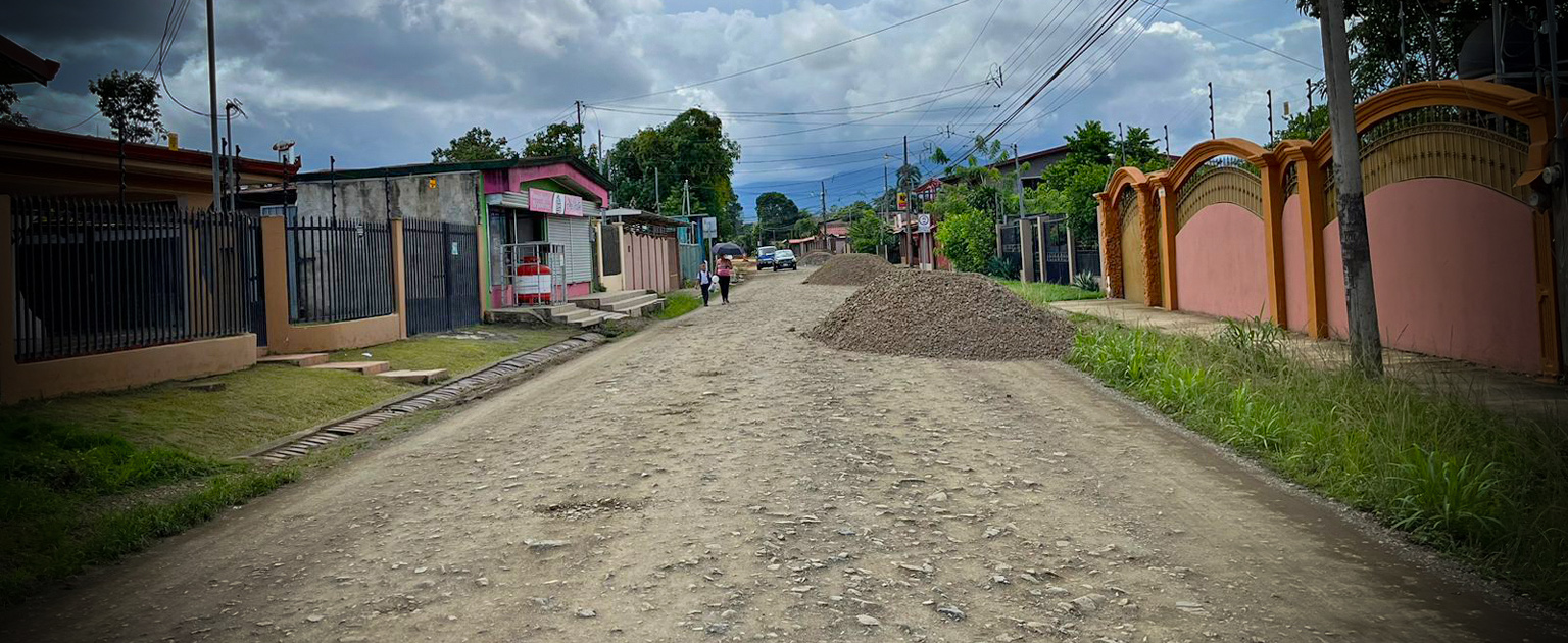 Calle en pavimento, con montículos de tierra