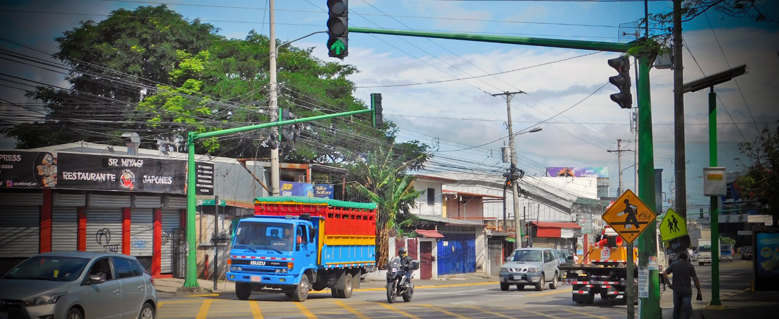 Camión y moto haciendo alto en semáforo rojo