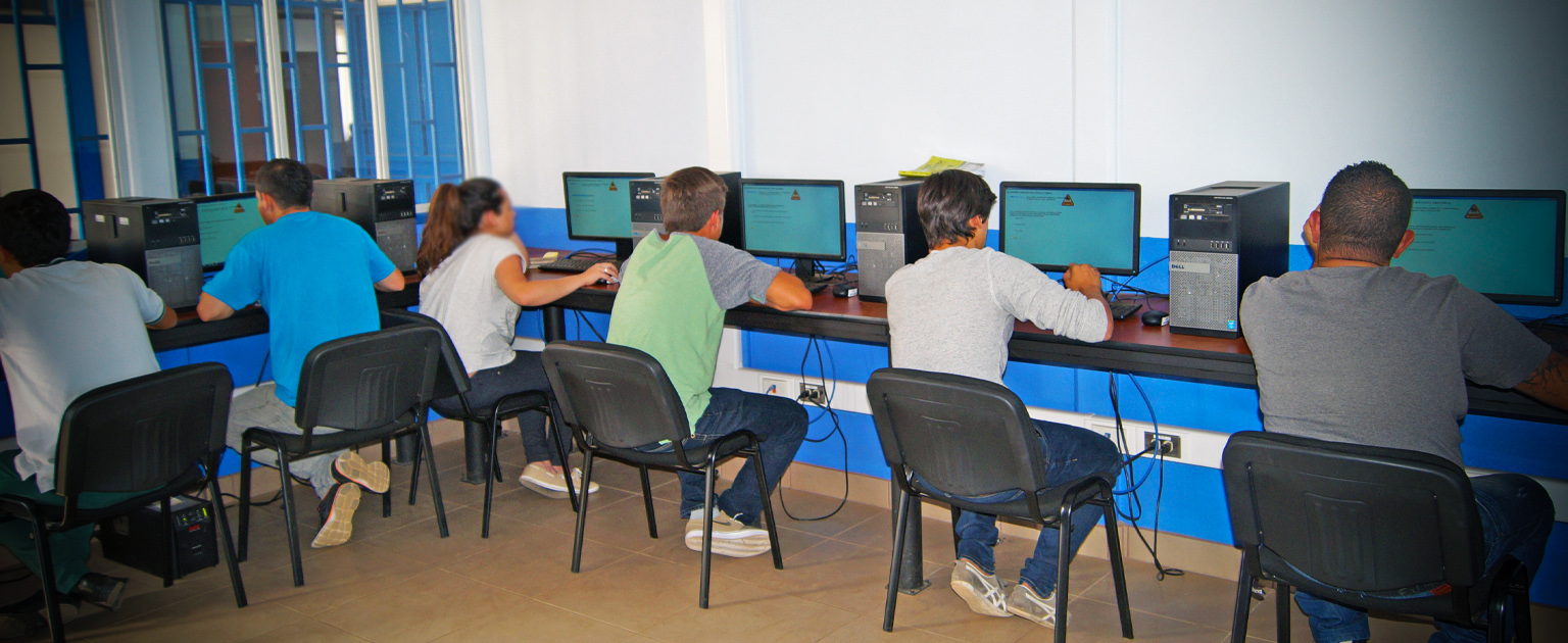 Usuarios en aula, sentados frente a sus computadoras