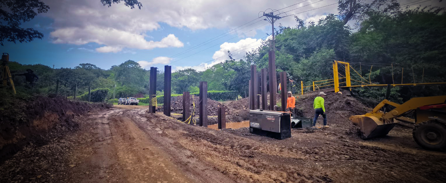 Maquinaria, personal trabajando en las bases del puente.
