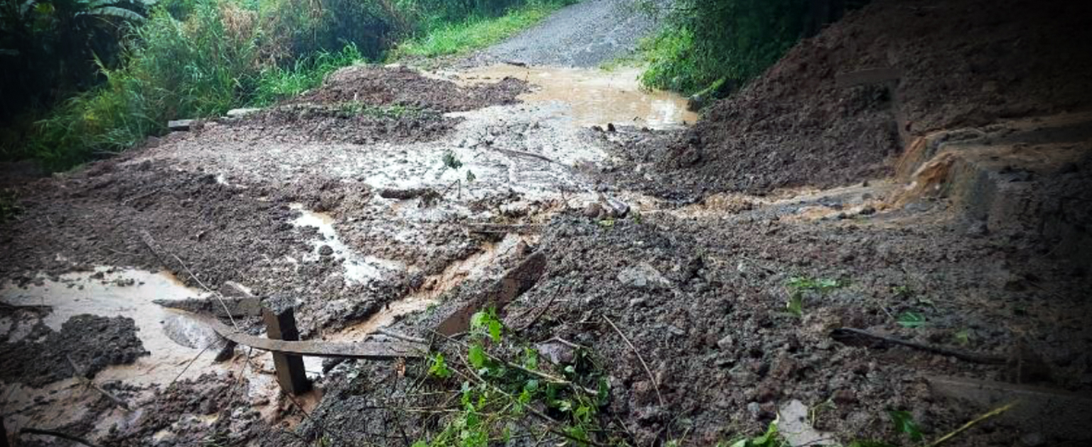 Material de tierra, barro, matas y agua  al fondo de la montaña, como producto del desprendimiento. 