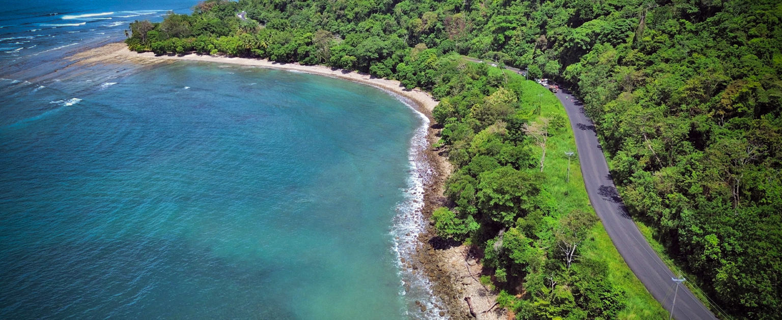 Foto aérea de la Costanera. al lado izquierdo el mar y derecho montaña. 