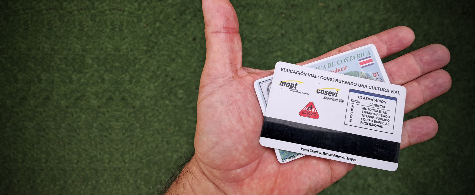 Fotografía que muestra una mano sosteniendo dos licencias