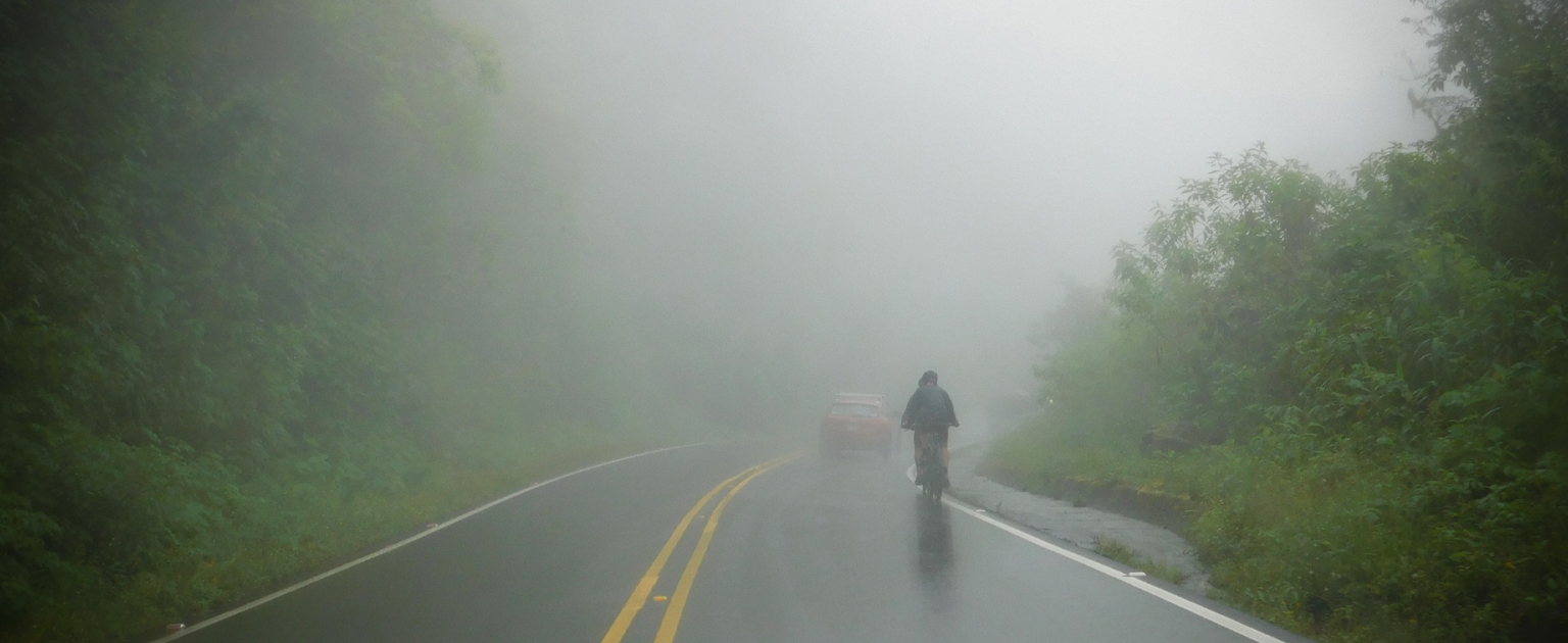 Ciclista transitando por carretera nublada y poca visibilidad 