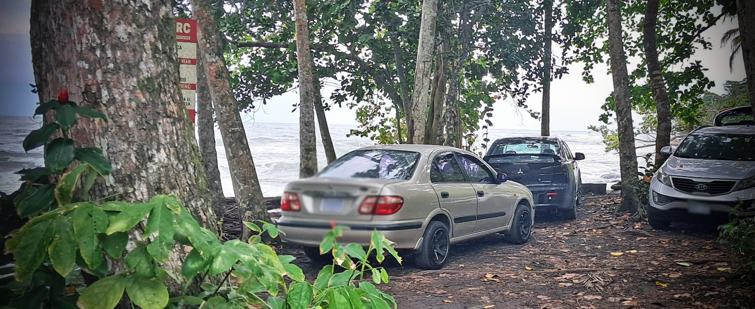 Fotografía de carros estacionados a la orilla de la playa. 