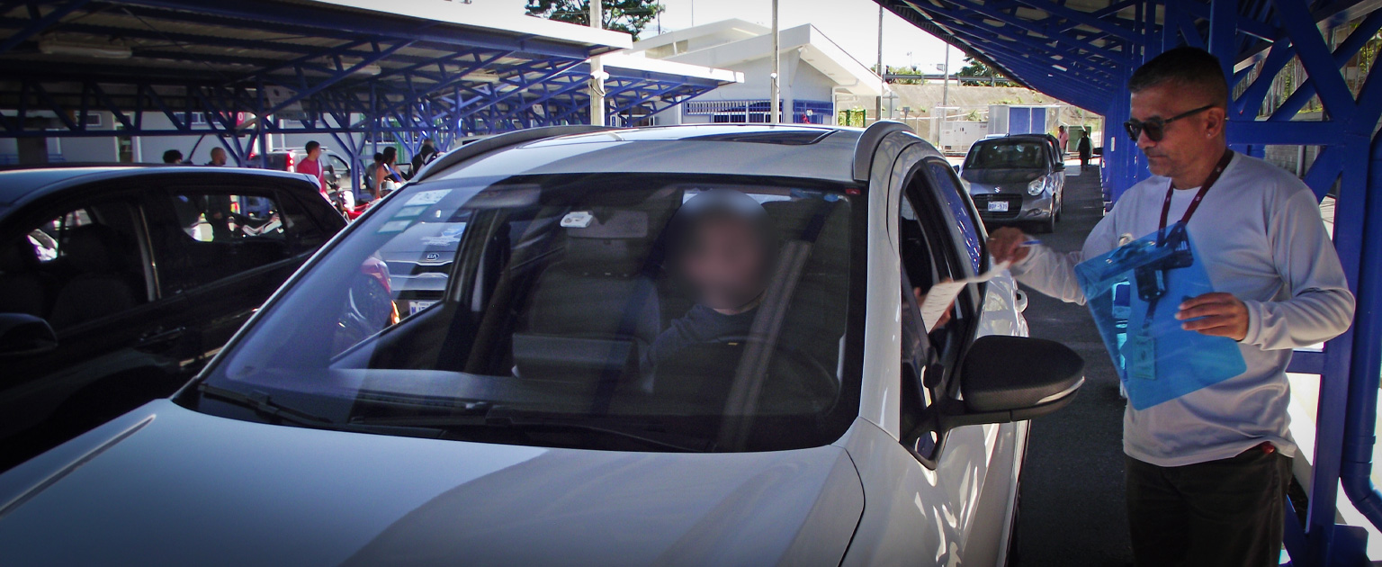 Fotografía que muestra a un evaluador revisando un vehículo antes de la prueba práctica