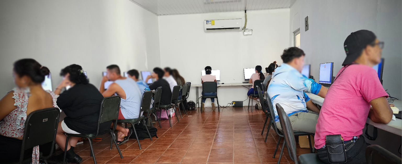 Usuarios en aula, ahciendo examen en computadoras