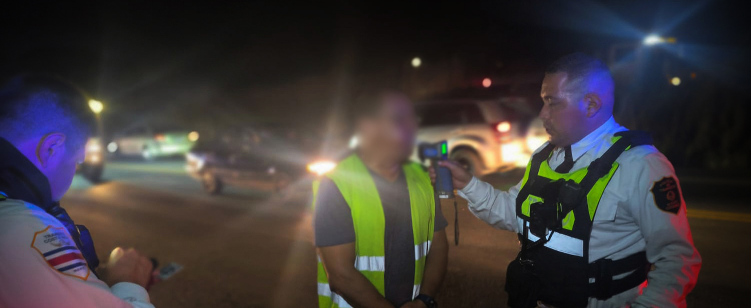 Policía de tránsito realiza prueba de alcoholemia a conductor en la vía pública durante un operativo nocturno