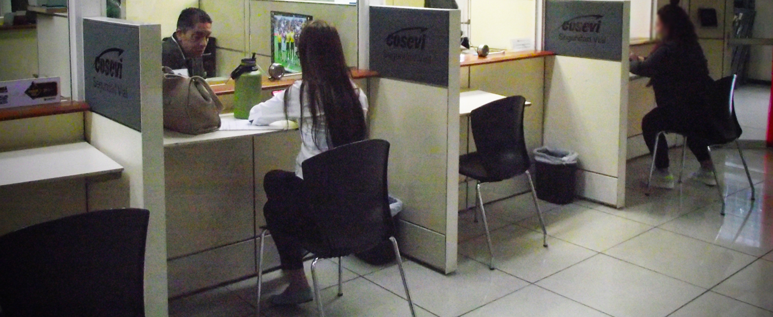 Fotografía que muestra a algunos usuarios en las ventanillas de atención al público de COSEVI