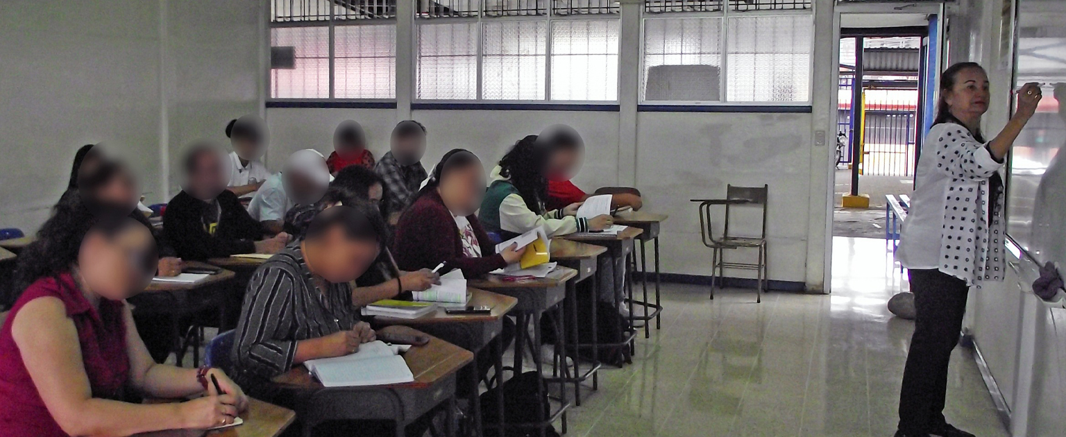 Fotografía que muestra a un grupo de personas en un aula recibiendo el curso teórico