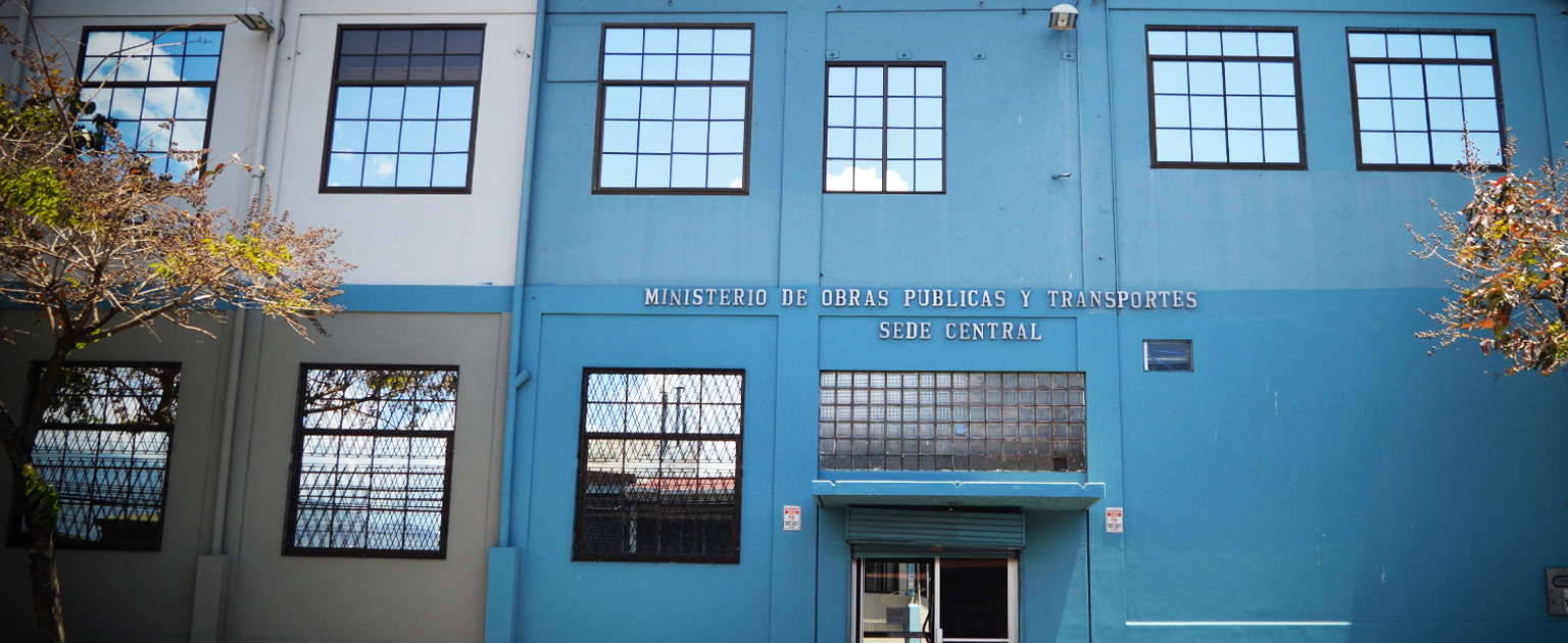 Edificio de la sede central del Ministerio de Obras Públicas y Transportes, con fachada azul, ventanas amplias y entrada principal visible