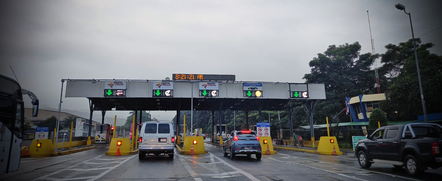 Estación de peaje en la carretera Florencio del Castillo, en Tres Ríos de La Unión con varios carriles habilitados para el cobro electrónico y manual. Se observan vehículos ligeros, autobuses y camiones circulando por las distintas casetas, señalizadas con indicadores luminosos y dispositivos de control de acceso