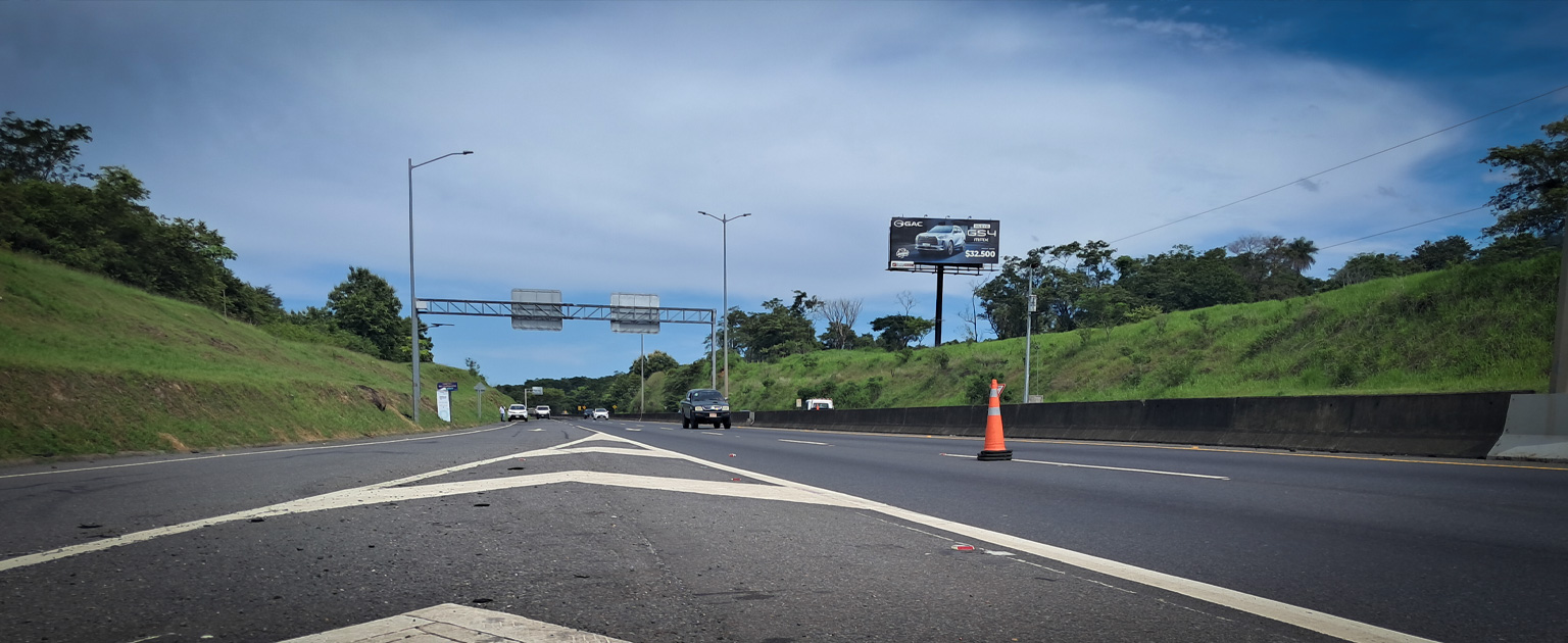 Vista de la Ruta Nacional 27 con varios vehículos en circulación. La carretera se encuentra rodeada de áreas verdes y cuenta con señalización vial y un cono de tránsito en uno de los carriles