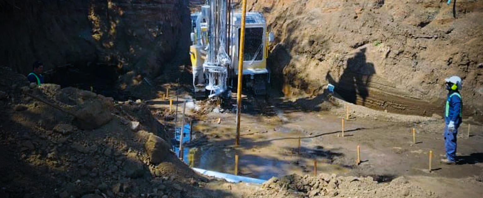 Fotografía que muestra maquinaria en labores de perforación para la hinca de pilotes en el puente sobre el río Soncoyo