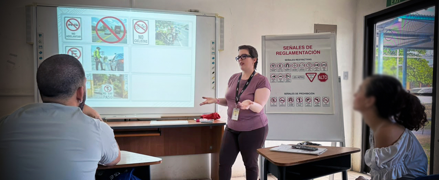 Fotografía que muestra una instructora impartiendo el curso teórico de manejo en LESCO