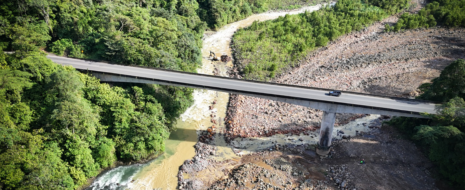 Vista aérea del puente que cruza el río Sucio con cauce reducido y fondo pedregoso, rodeado de vegetación