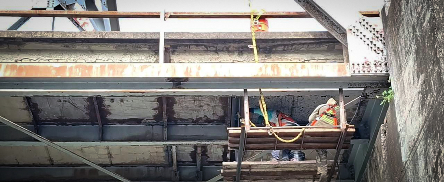 Fotografía que muestra parte de la subestructura del puente y trabajadores interviniéndola